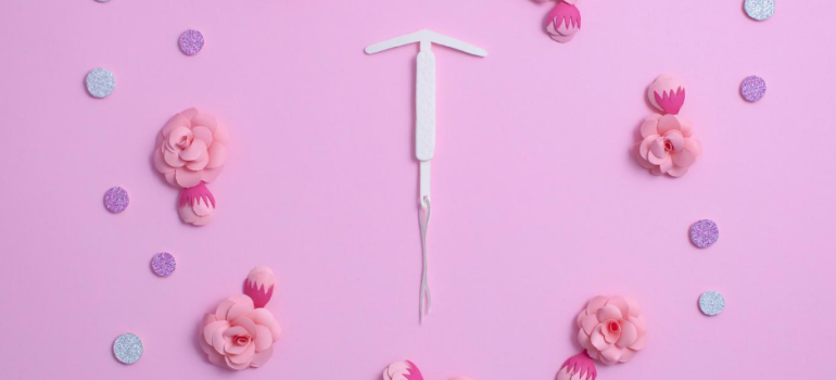 An IUD surrounded by flowers and polkadots