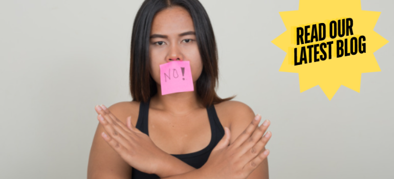 Woman with her arms crossed and note on her mouth that says 'no!'.